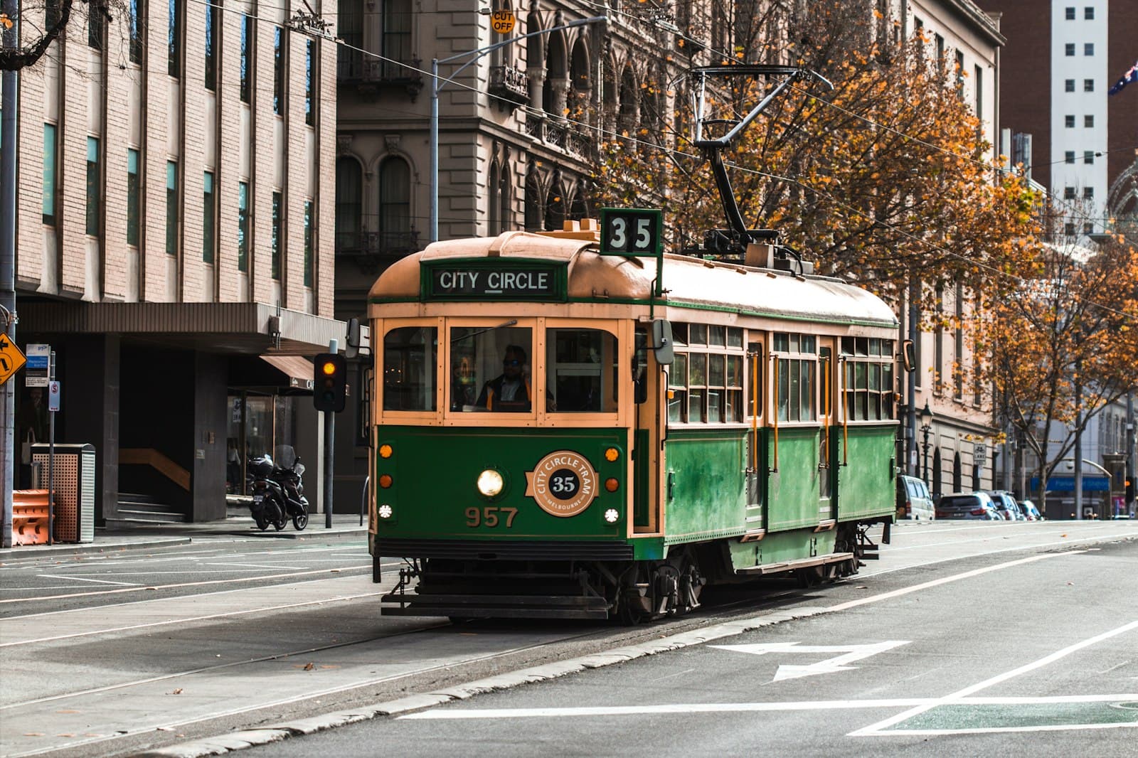 A heritage green and gold City Circle tram travelling through central Melbourne